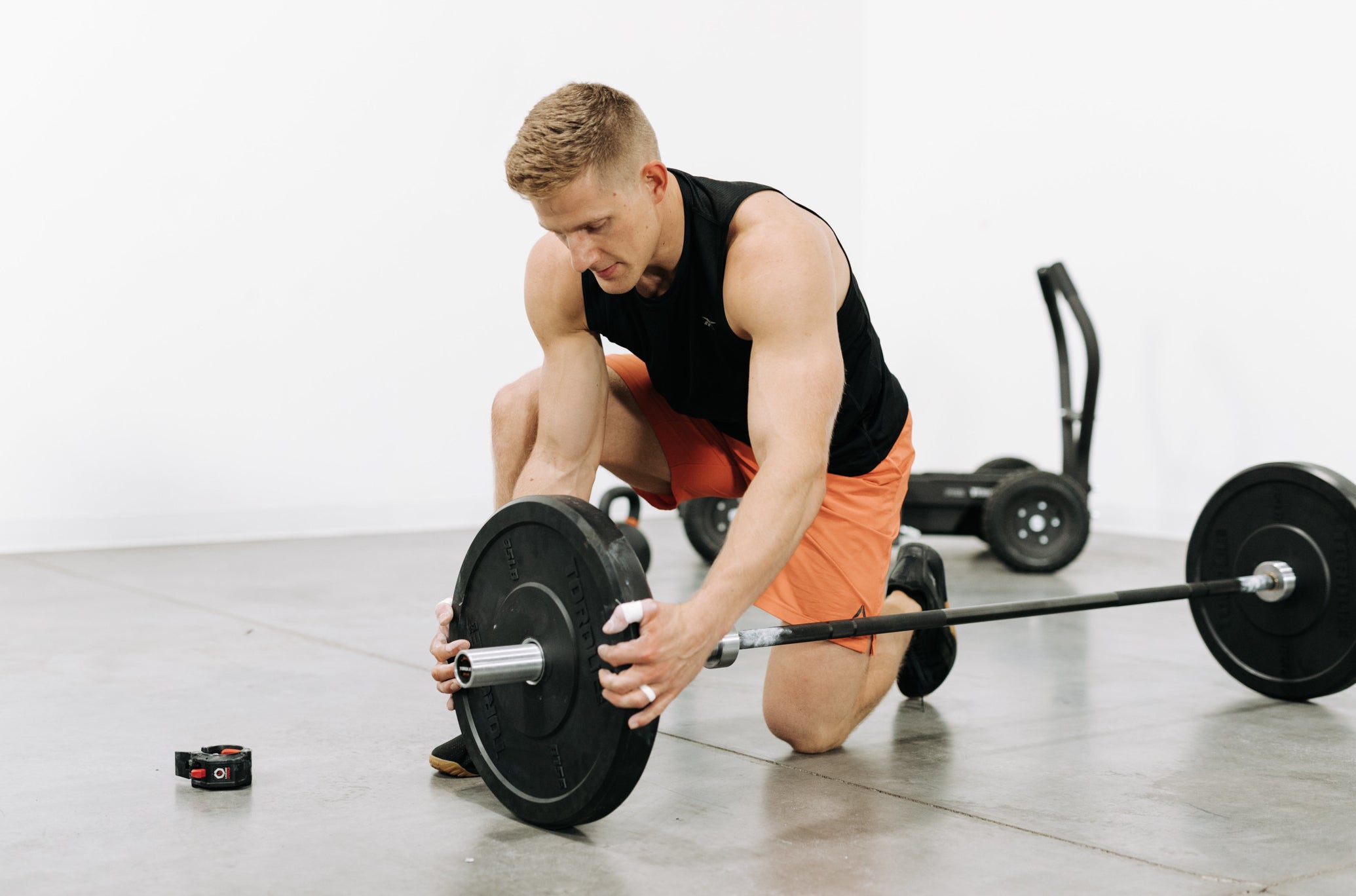 Brent Fikowski Putting Torque Black Bumper Plate Onto Barbell<black>