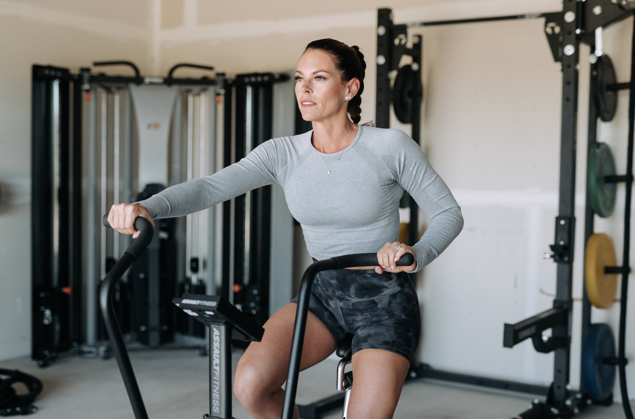 Woman Working Out With AssaultBike In Home Gym
