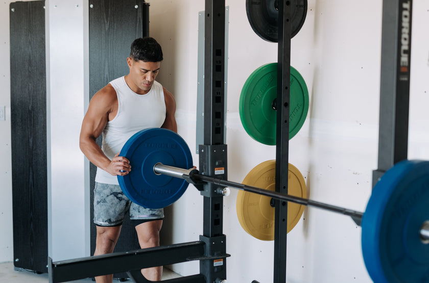 Man Loading Plates Onto Torque Rack