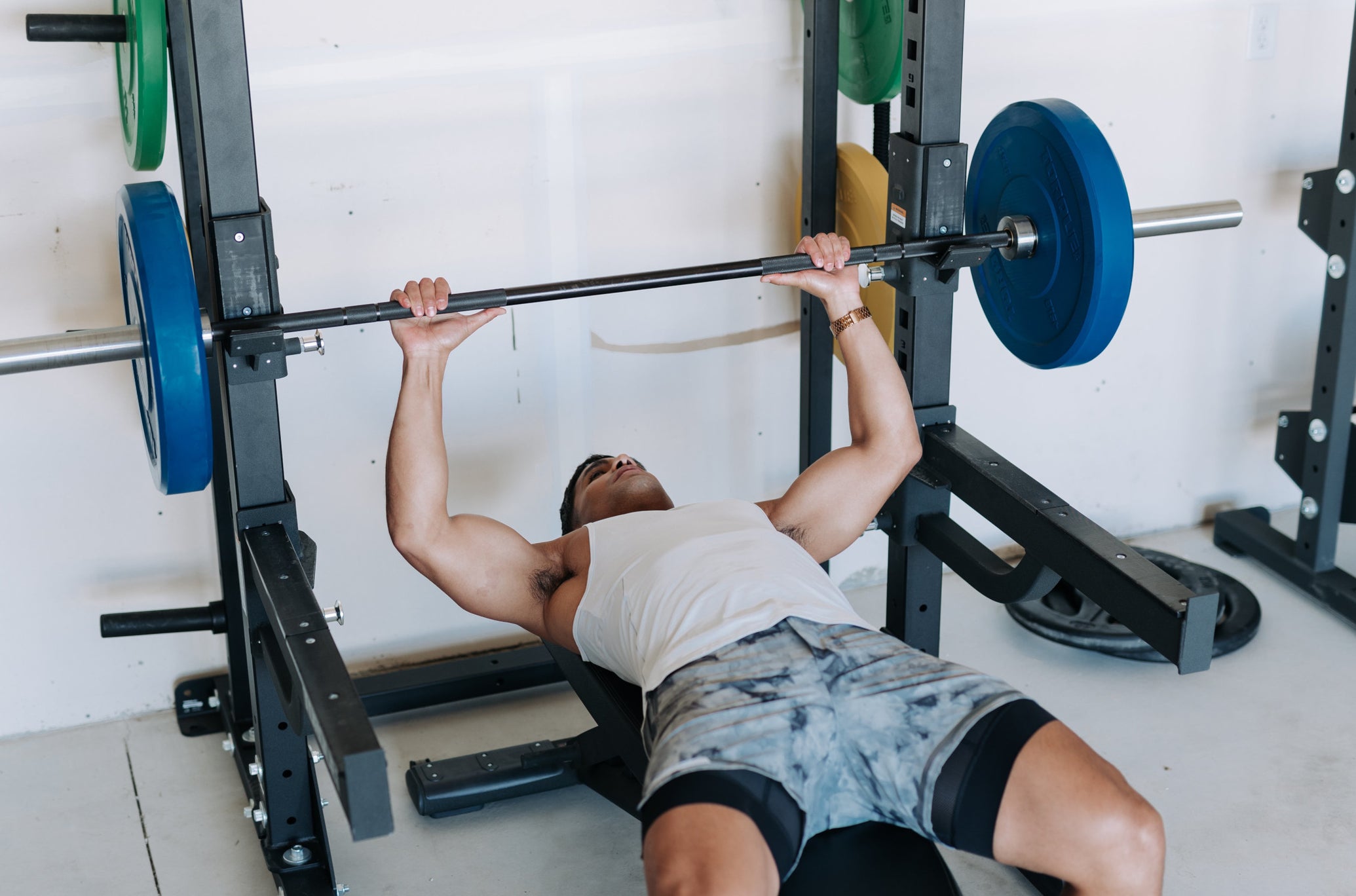 Man Lifting Bar and Plates On Rack